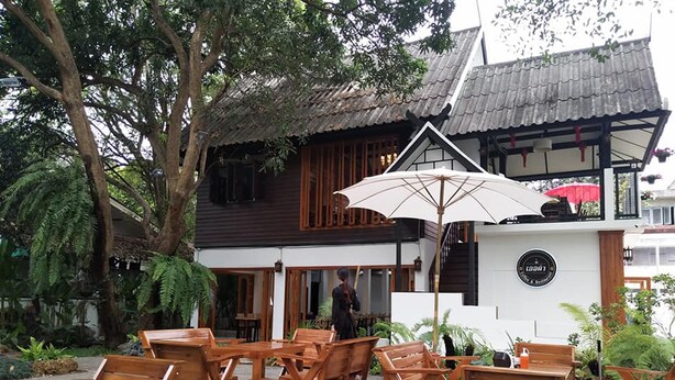 Un espace extérieur aménagé avec des meubles en bois et un grand parasol.