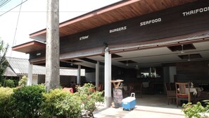A restaurant with a signboard indicating it serves burgers, steak, and seafood.