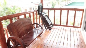 A wooden bench with a metal frame on a wooden deck. - Mookdamun Bungalows (Ko Yao)
