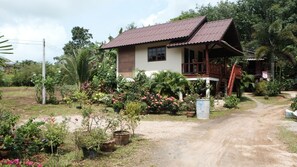 A single-story house with a brown metal roof and a porch.