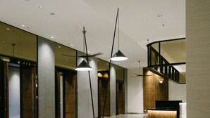 A modern lobby with a reception desk, seating area, and a staircase. - Avillion Cameron Highlands (Tanah Rata)