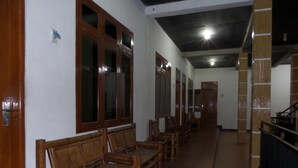 Un pasillo con bancos de madera y puertas, que conduce a una escalera.