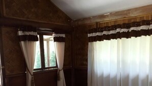 Un dormitorio con cama, cortinas y ventana.