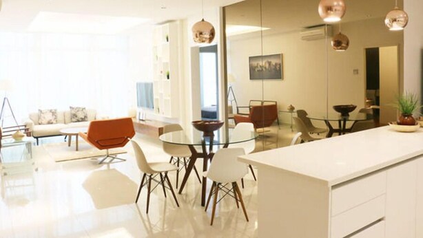 A modern kitchen with a central island, white cabinetry, and pendant lighting.