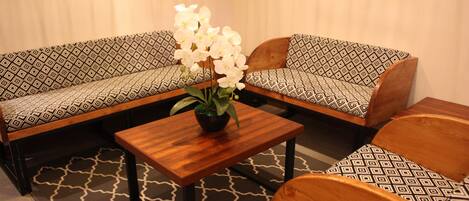 Una habitación con un sofá, una pequeña mesa y una silla.
