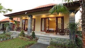 A hotel with a covered outdoor area, a dining setup, and a staircase leading to the entrance. - Darra Ria Villa Ubud (Ubud)