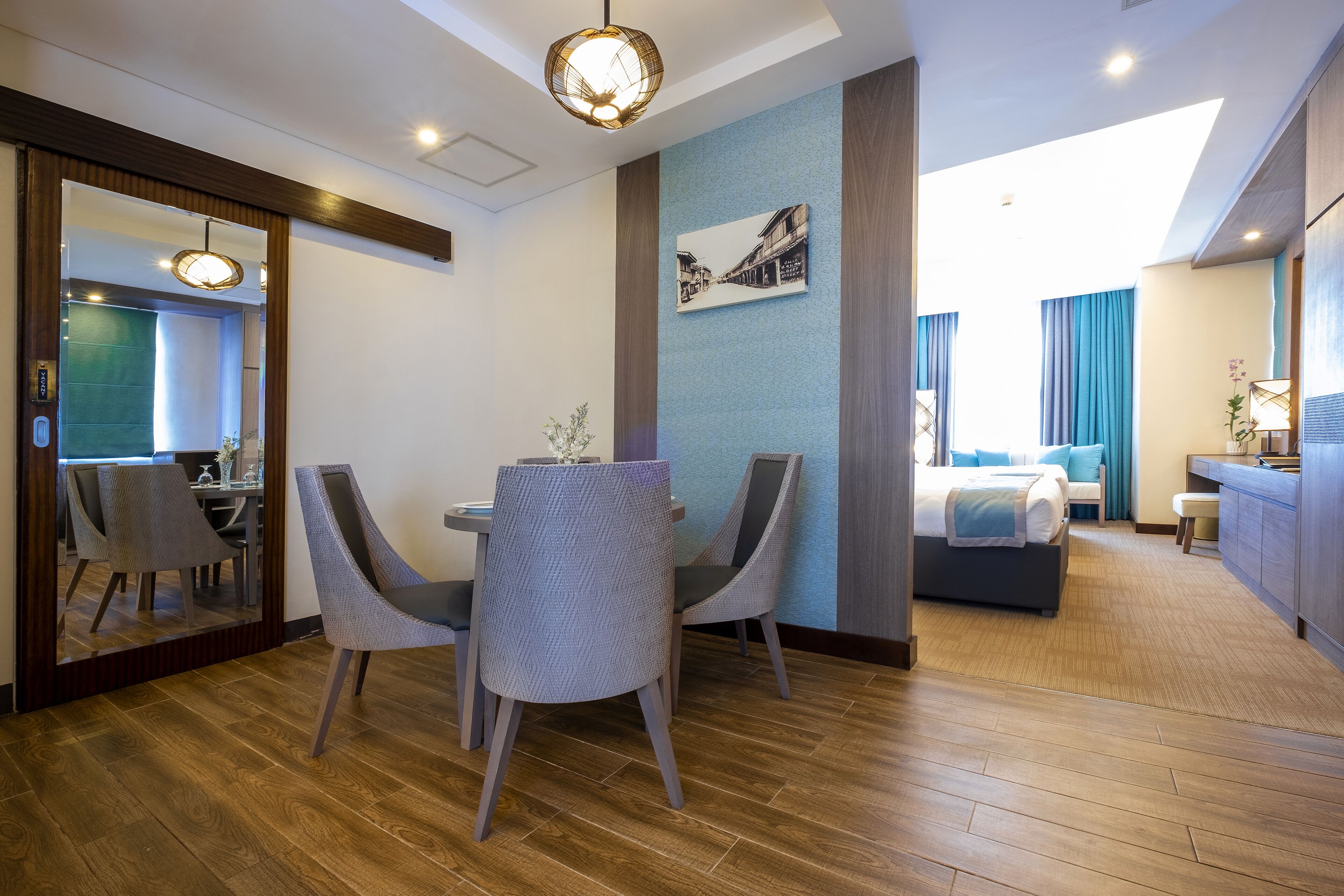 Habitación de hotel con comedor, cama, baño y vistas a la ciudad.
