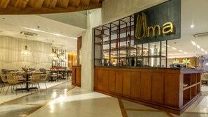Un espace bar moderne avec un comptoir en bois et une vitrine où sont exposées les bouteilles.