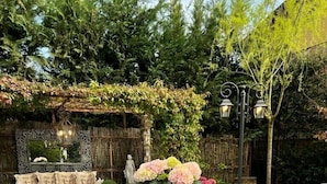 An outdoor dining area with wicker chairs and a table set for a meal.