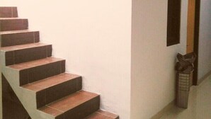 A staircase with dark wooden steps leading to a landing. - Adikarta Guesthouse Janti (Banguntapan)