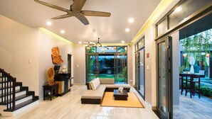 A modern living room with a sofa, coffee table, and a ceiling fan. - Dai An Phu Villa (Da Nang)