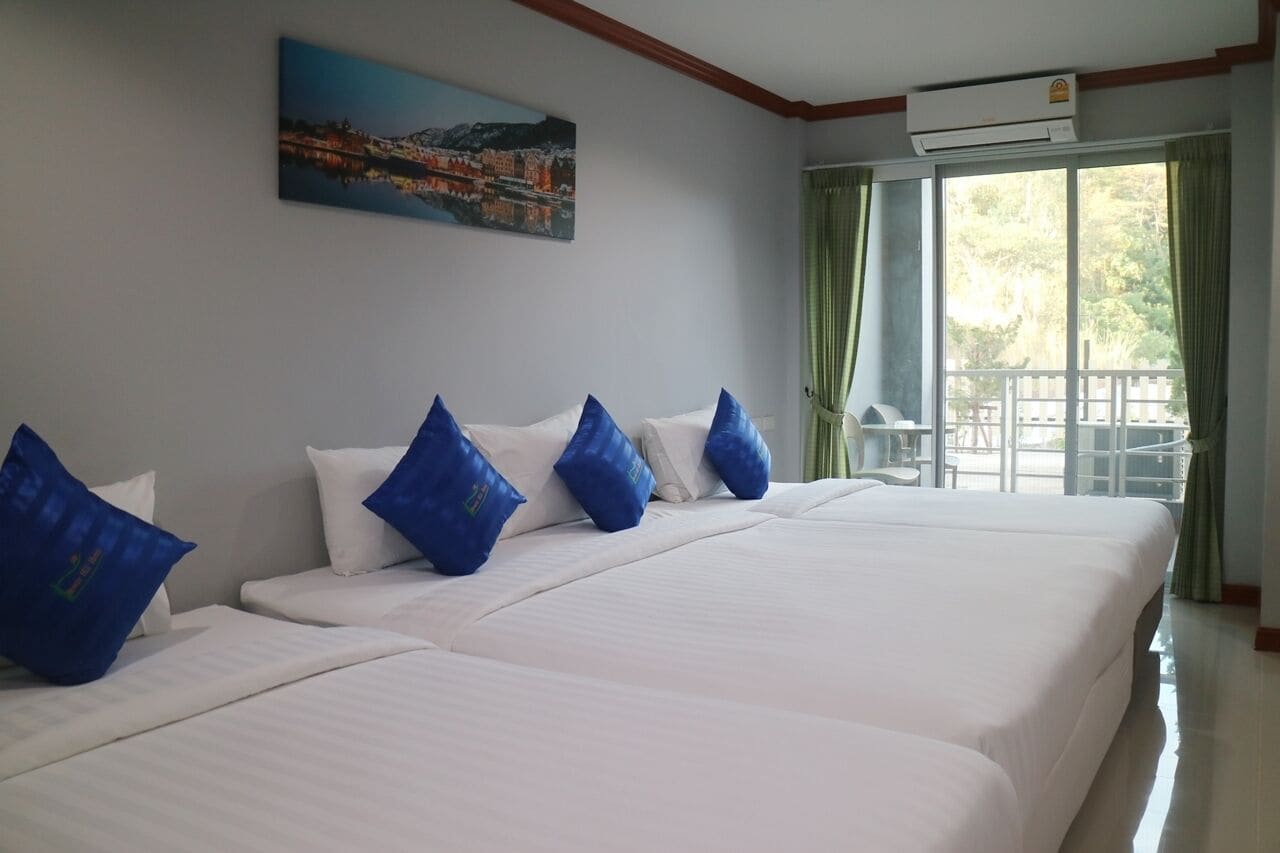 Habitación de hotel con dos camas, un cuadro en la pared y una ventana con cortinas.
