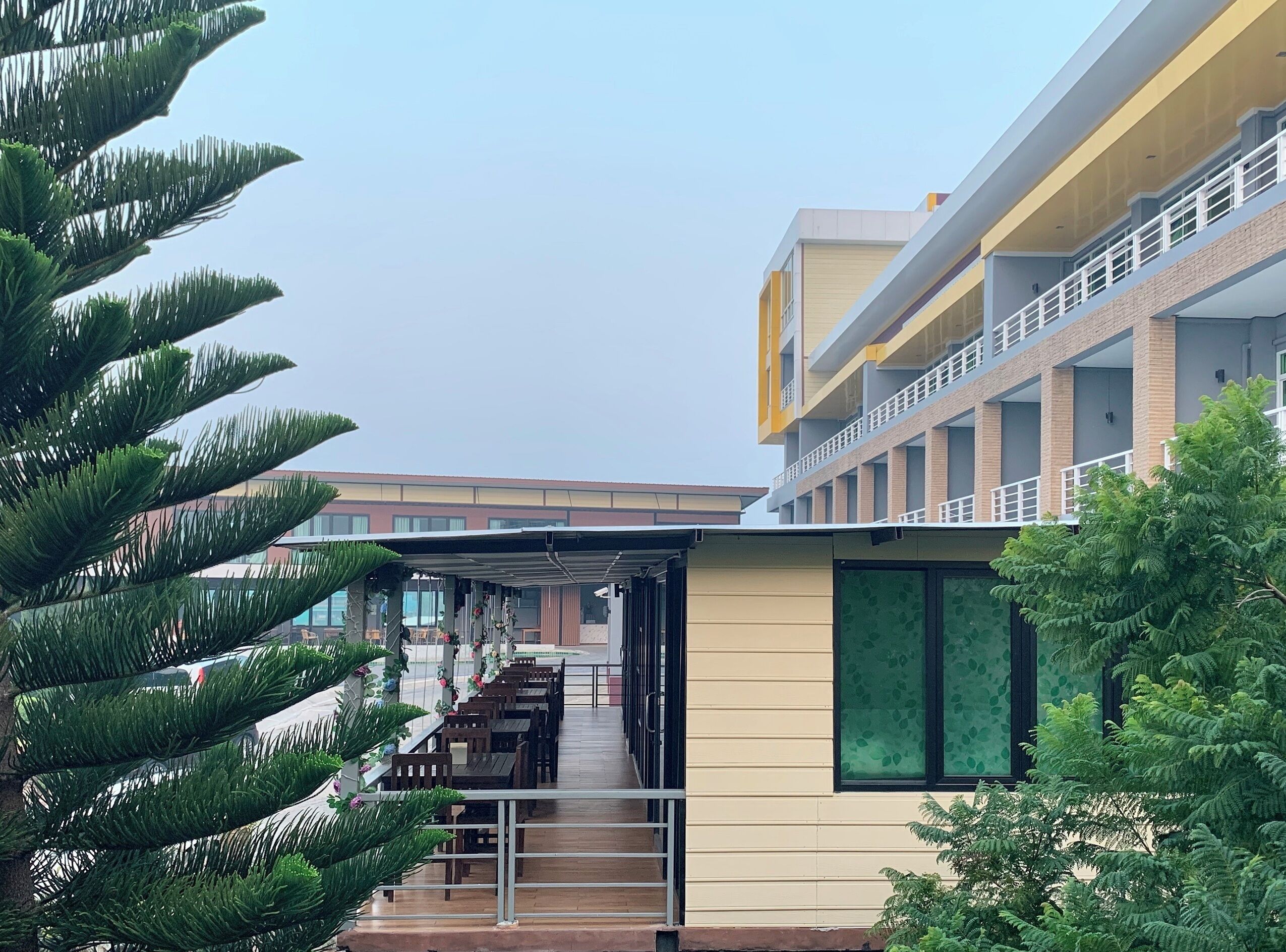 Un edificio moderno con un área de estar cubierta al aire libre y una escalera que conduce a un nivel superior.