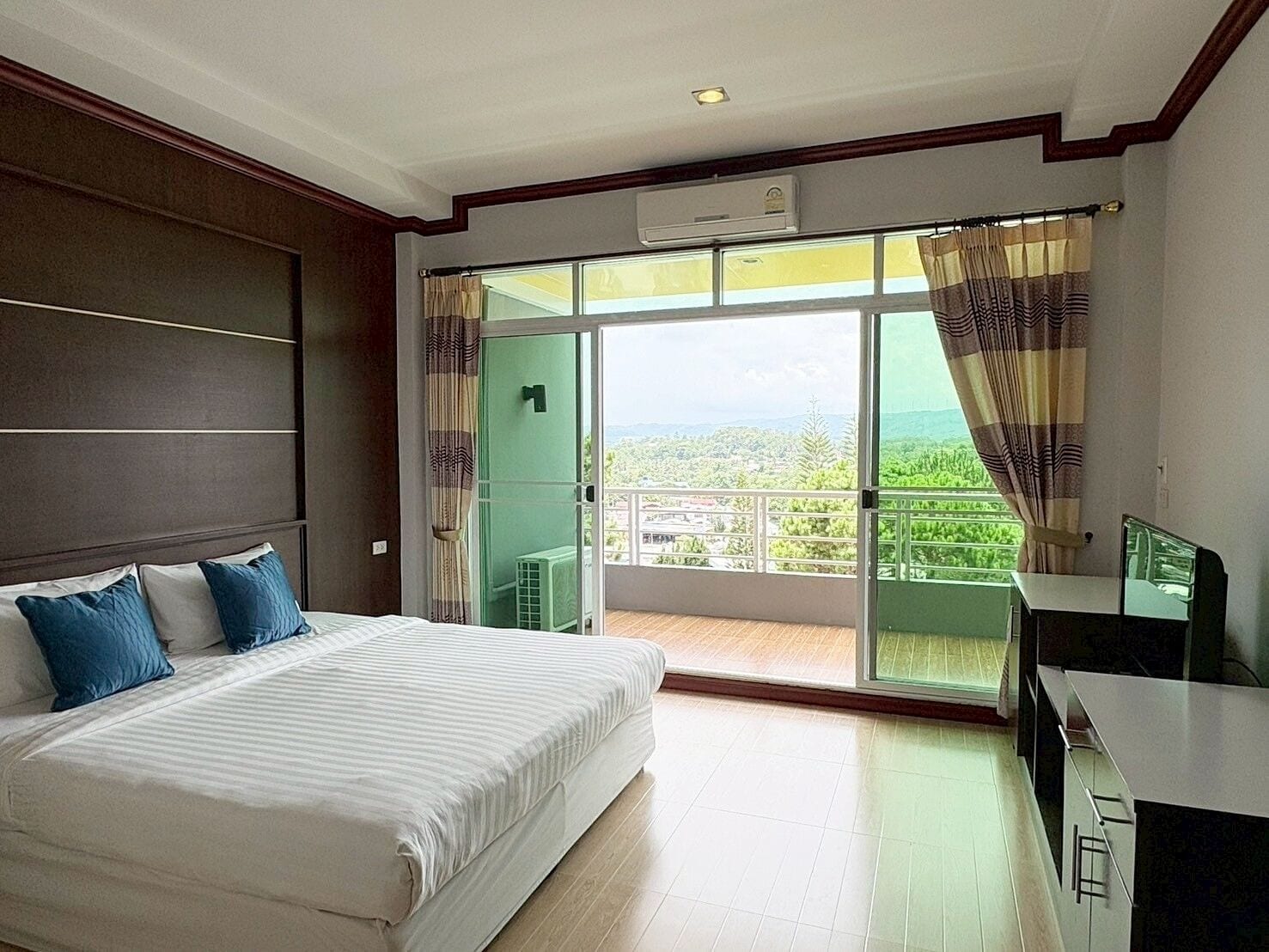 Une chambre d’hôtel avec un grand lit, un bureau et un balcon offrant une vue agréable.