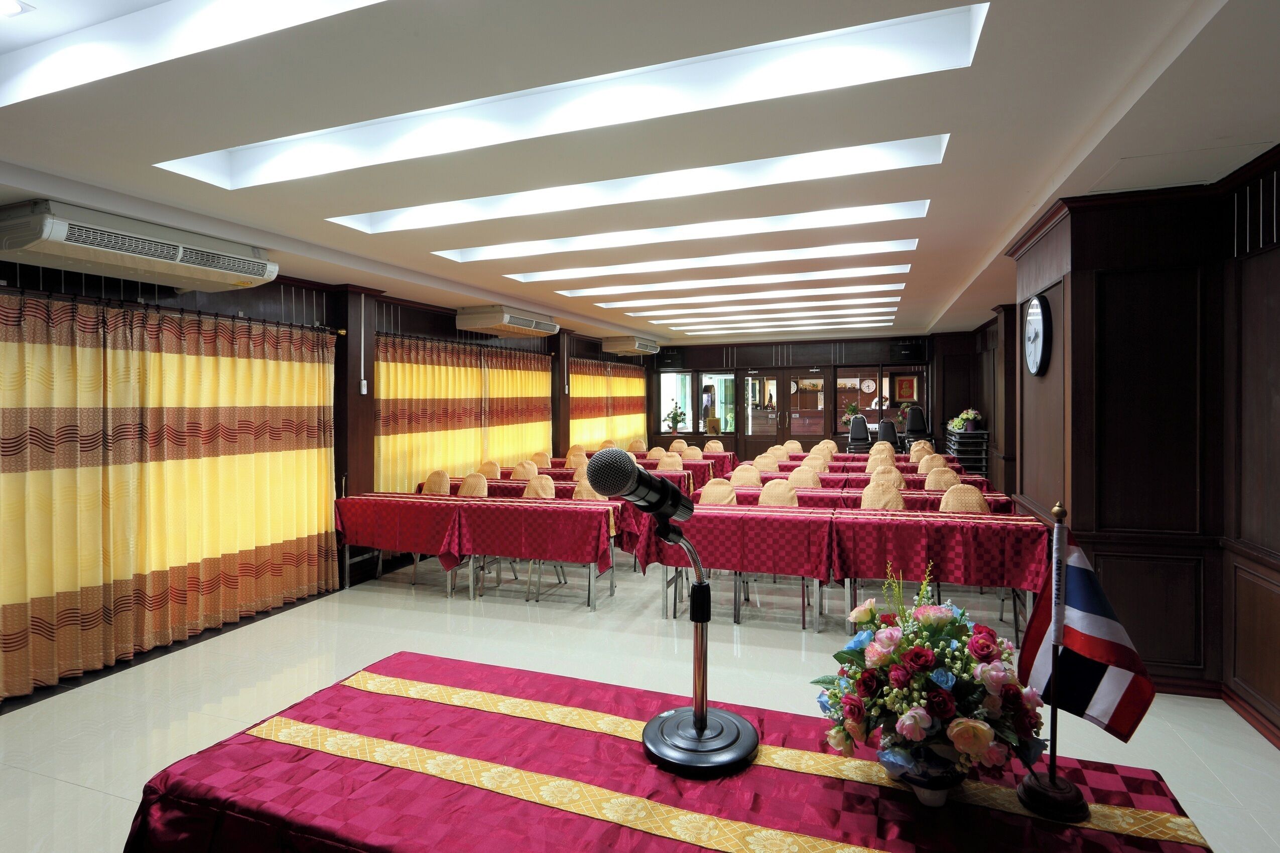 A conference room with tables set for a meeting, a podium, and a flag.