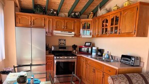 A compact kitchen with wooden cabinets, a refrigerator, a stove, and a toaster. - Beachfront Villa/Sleeps 8. Add Optional Casita for Larger Groups! Great views! (Playas De Tijuana)