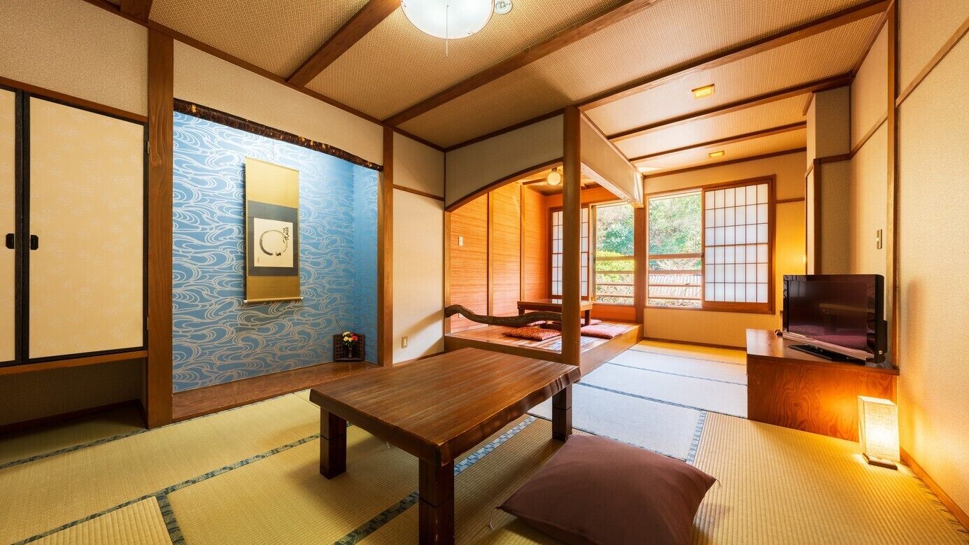 A traditional Japanese room with tatami flooring, sliding doors, and a television.