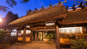 A traditional Japanese building with a thatched roof and wooden pillars. - Kurokawa Onsen Yamabiko Ryokan (Minamioguni)