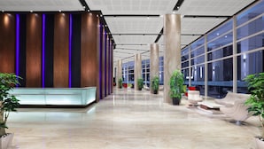 A spacious lobby with a reception desk, seating area, and large windows. - Aston Batam Hotel & Residence (Batam)
