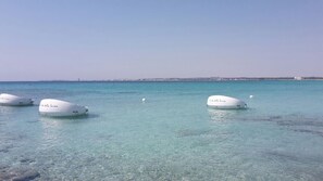 Tres barcas blancas con la inscripción "Punta della Regina" flotando en aguas azul turquesa.