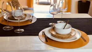 Una tavola imbandita con bicchieri da vino, piatti e una ciotola di zuppa.