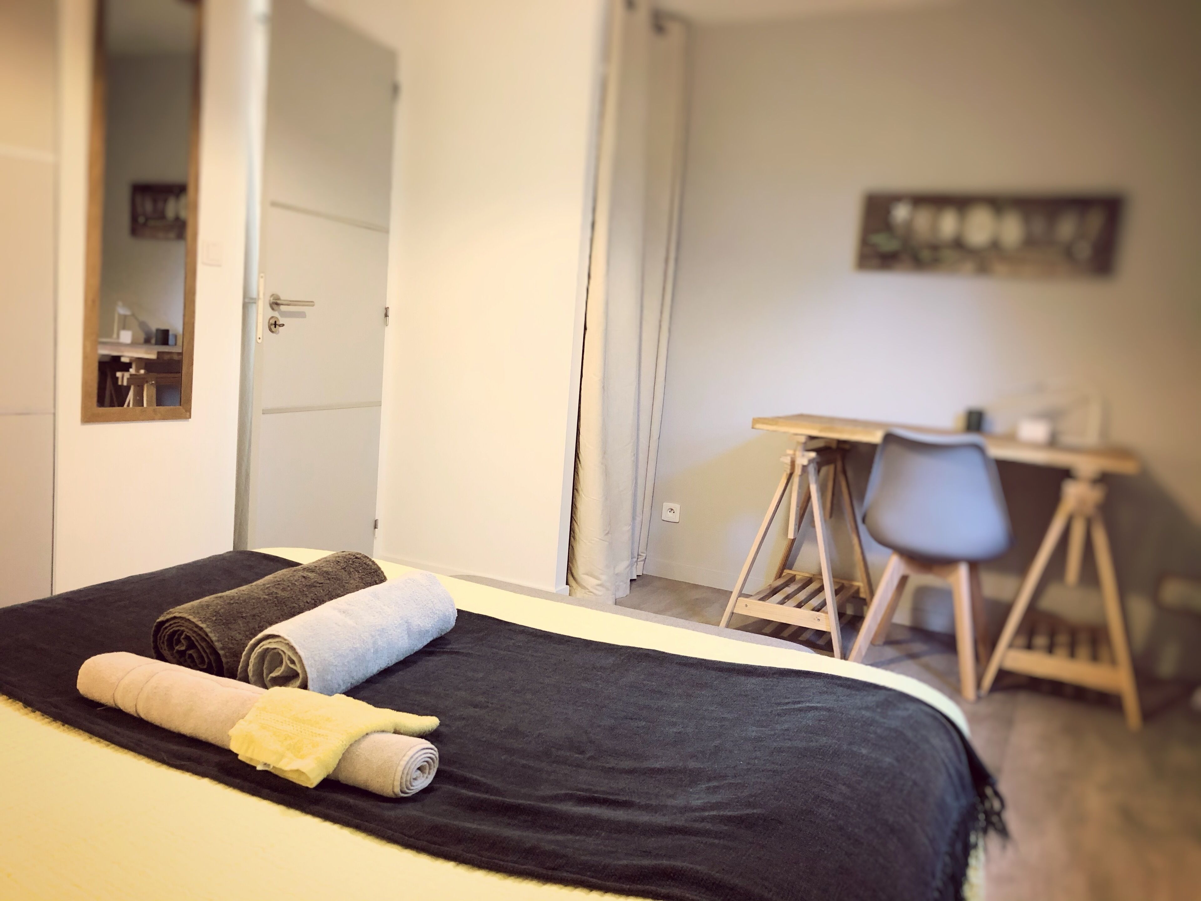 A bedroom with a bed, a desk, and a chair.