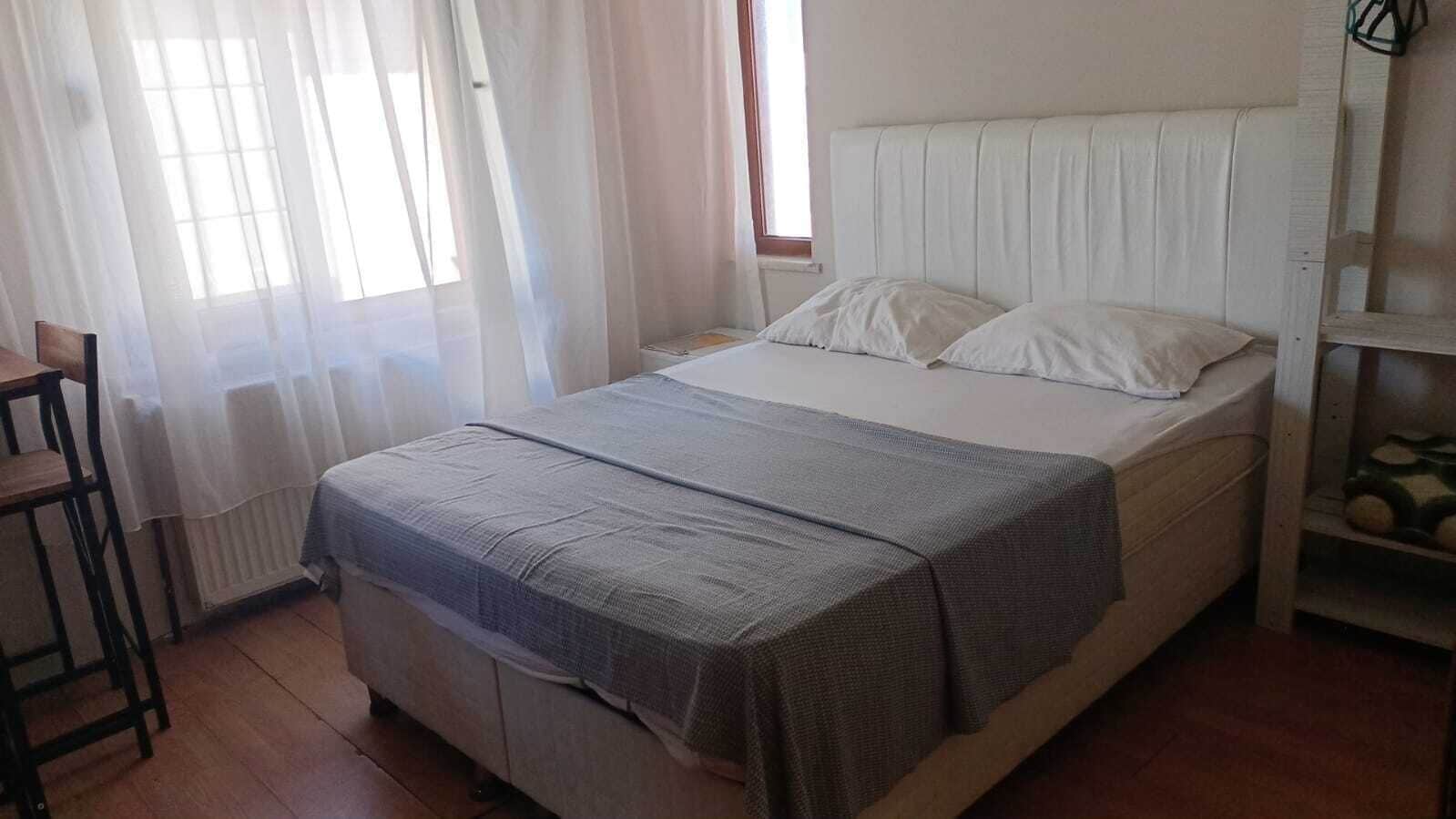 A single bed with a headboard, a bedside table, and a chair.