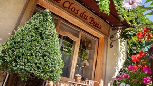 Un comercio rústico con un letrero de madera que dice "Le Clos du Bois".