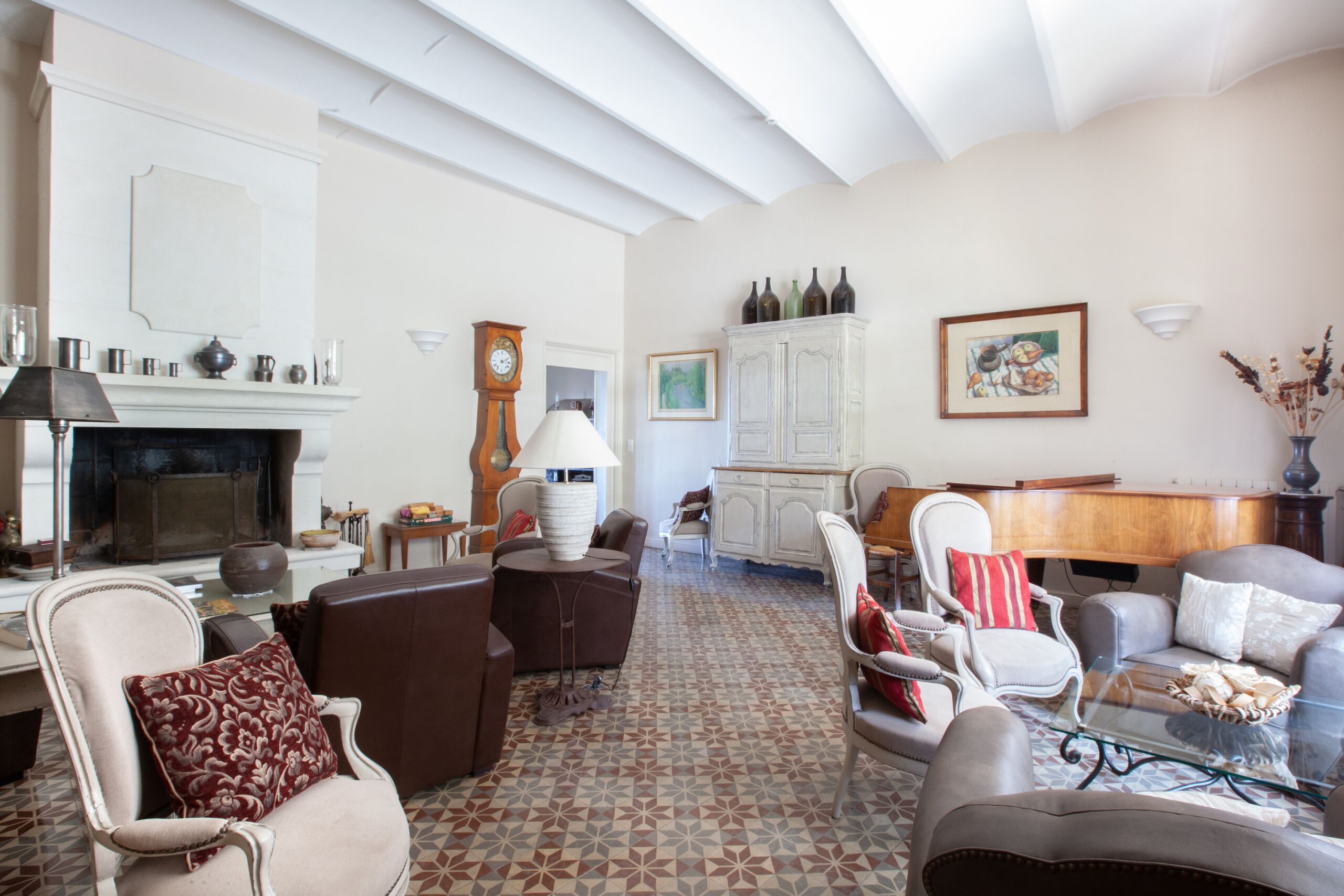 Un salon spacieux doté d’une cheminée, de sièges confortables, d’un piano et d’un meuble décoratif.