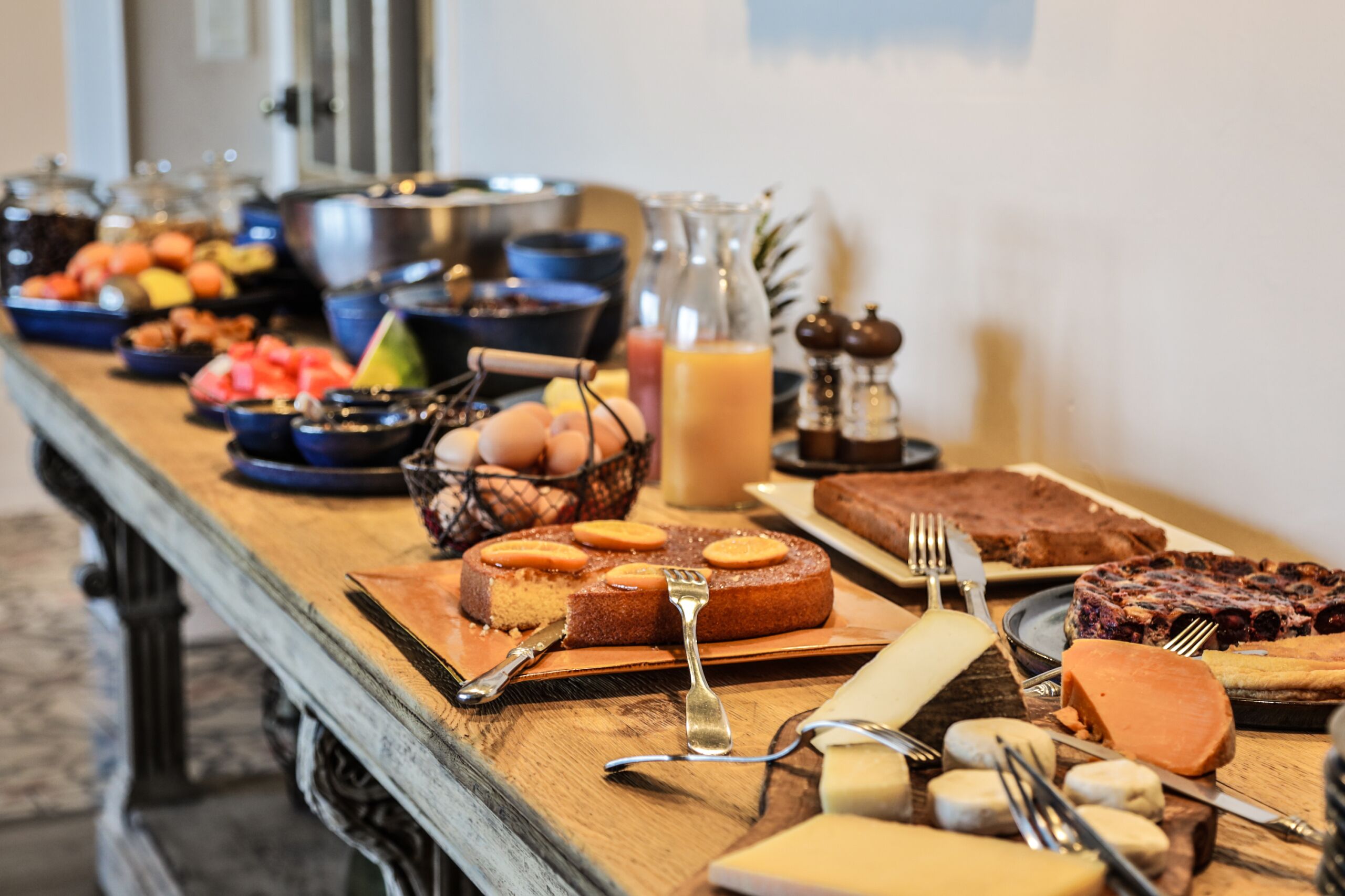 Um buffet de café da manhã com diversos alimentos e utensílios.