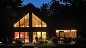A two-story house with large windows and a visible interior. - Beautiful four season chalet in northern Wisconsin Lakeshore (Siren)