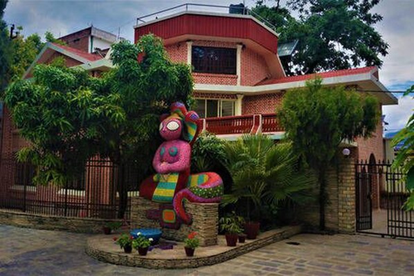 A house with a unique, colorful sculpture in the front yard. - Tangalwood Boutique Hotel (Kathmandu)