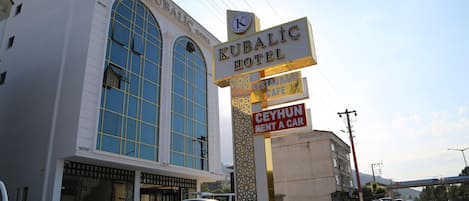 A hotel with a large arched window and a sign indicating it is the Kubalic Hotel.