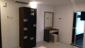 A hotel room with a large wardrobe, a vanity with a mirror, and a heart-shaped towel on the floor. - T Hotel Ipoh (Ipoh)