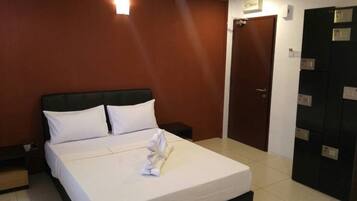 A hotel room with a bed, a nightstand, a wardrobe, and a door.