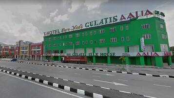 Un edificio verde con numerosas ventanas y un cartel que dice "GULATIS SILK HOUSE".