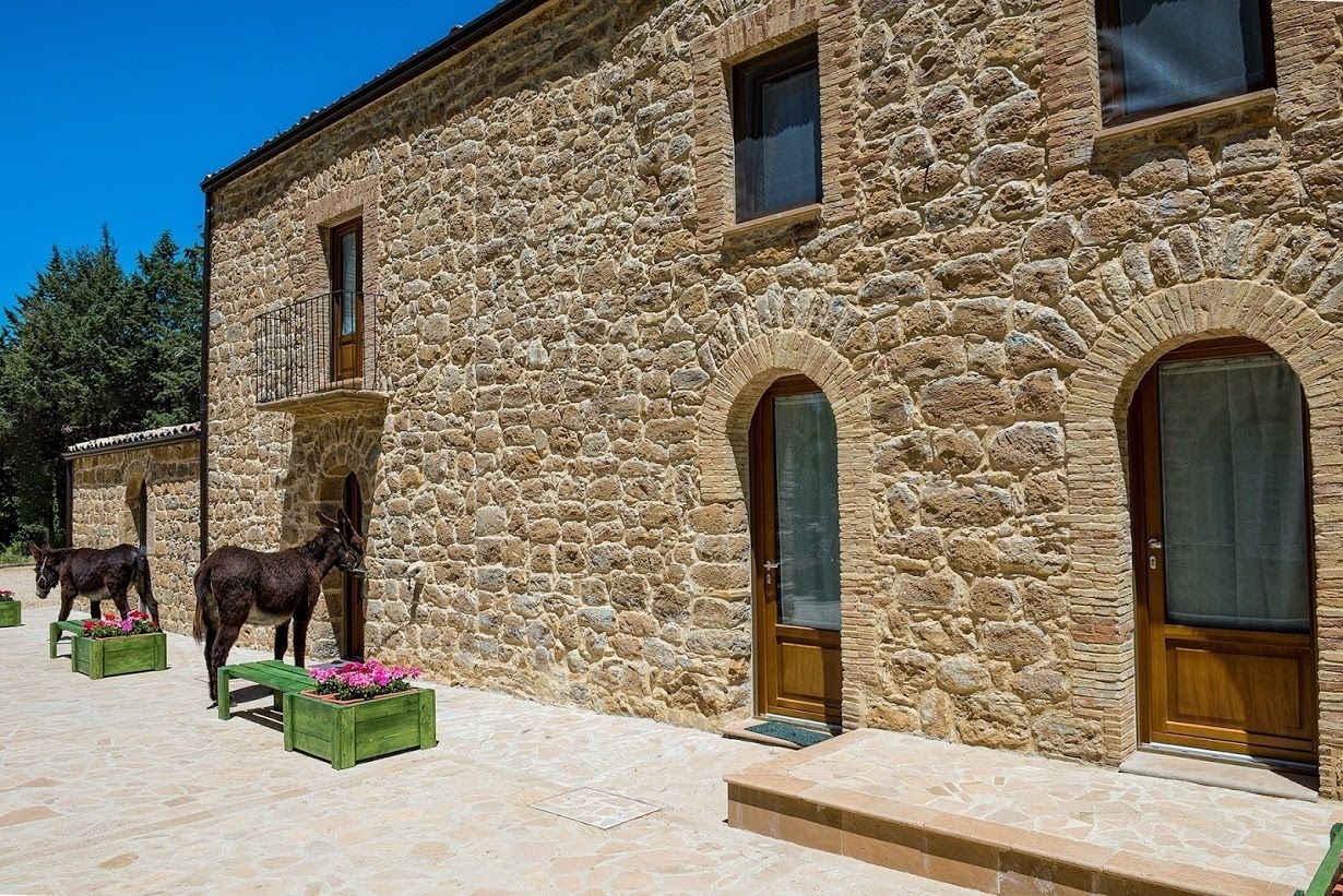 A stone building with arched windows and a wooden door.