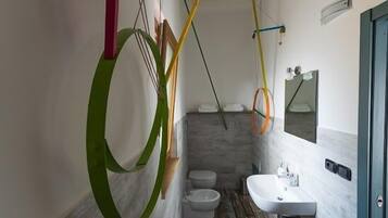 Un baño moderno con suelo de madera, un lavabo blanco y un espejo encima.