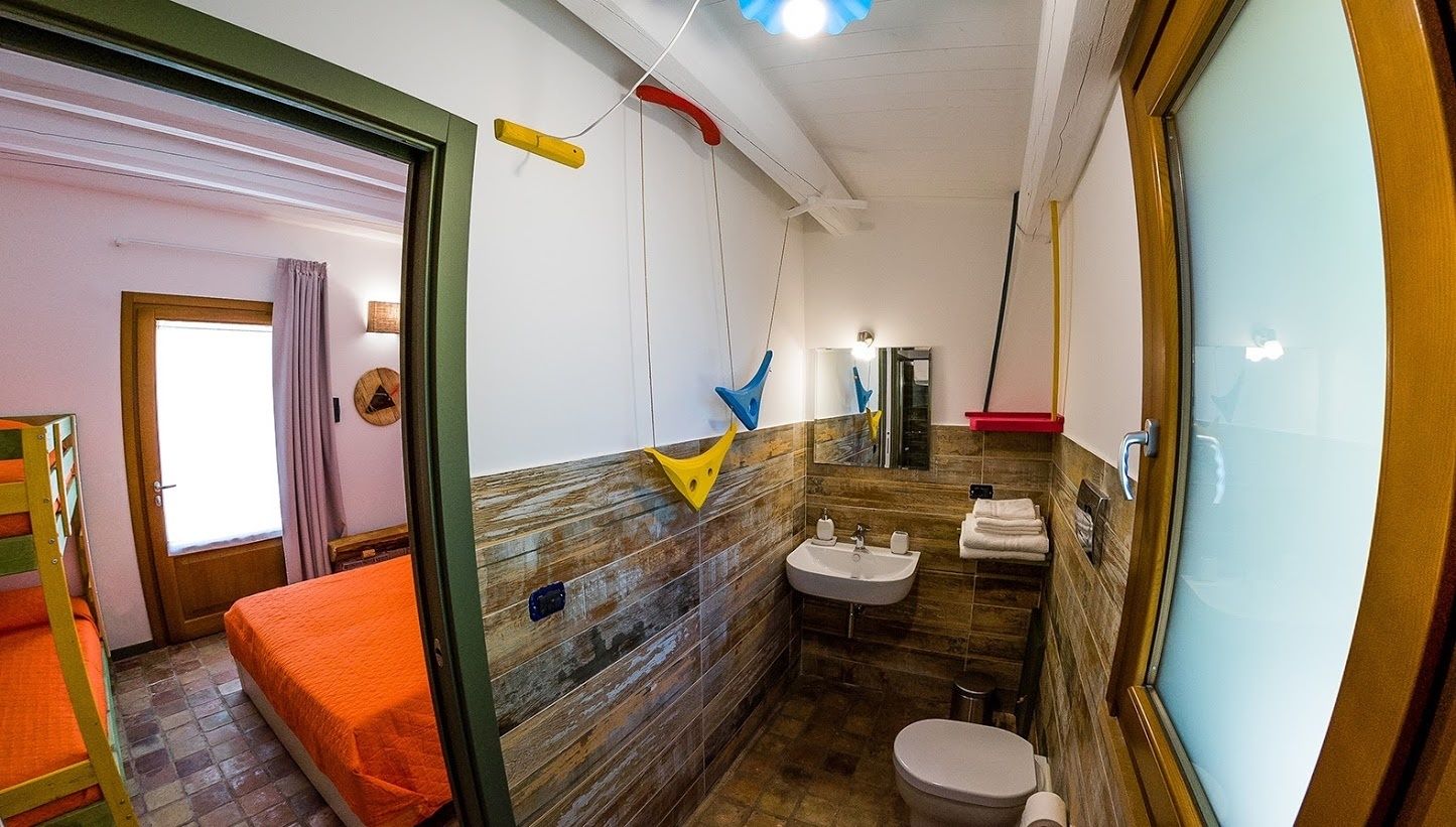 Een kleine badkamer met een houten wand, een wastafel en een toilet.