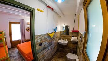 Een kleine badkamer met een houten wand, een wastafel en een toilet.