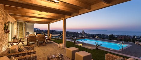 Una piscina al aire libre, una piscina infinita, sombrillas