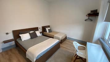 Un dormitorio con dos camas, un escritorio y una silla.