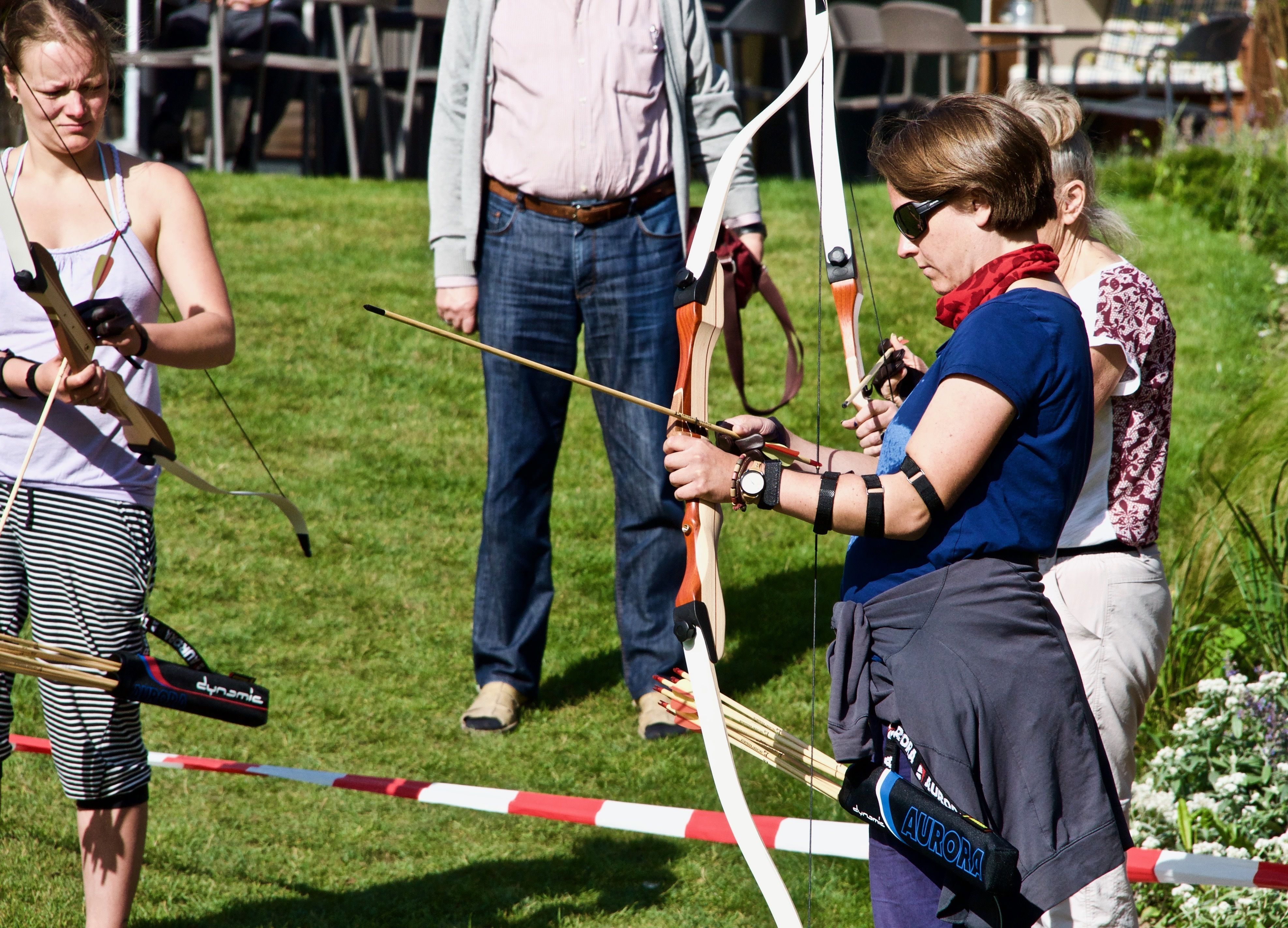 An outdoor archery range with participants and equipment.