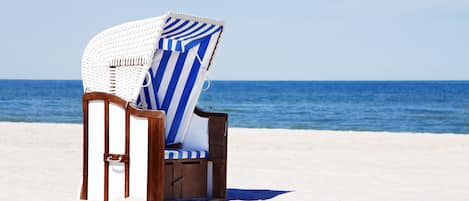 På stranden, solsenger, parasoller og strandyoga