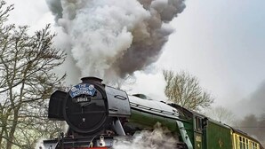 Eine Dampflokomotive mit der Nummer 60103, die Dampf abgibt, und mit der Aufschrift "The Flying Scotsman".