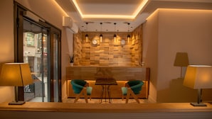 Un interior moderno con una pared de madera, dos sillas color turquesa, una mesita y dos lámparas.