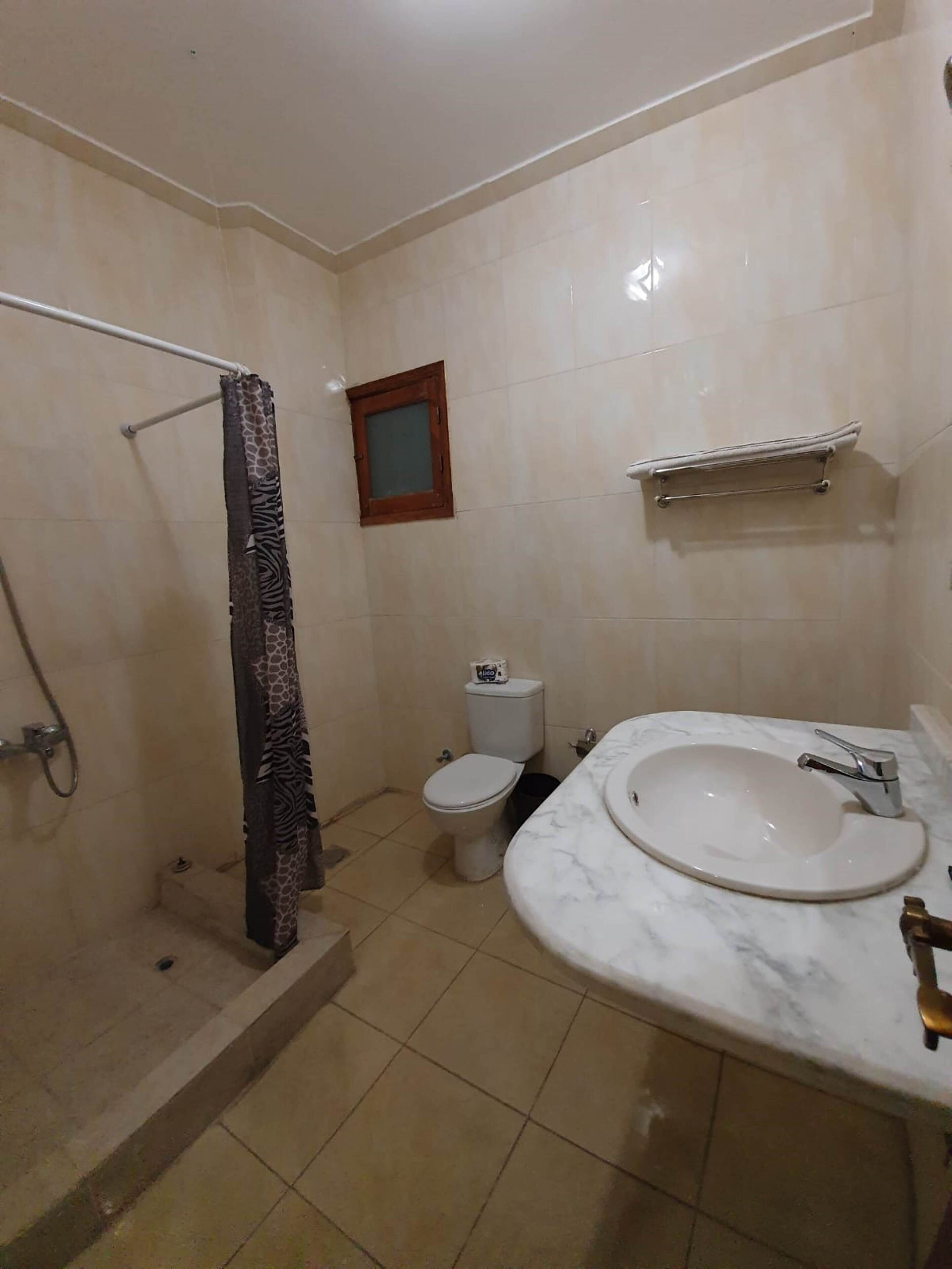 Un baño con ducha, inodoro y lavamanos.