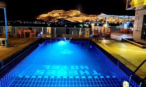 A swimming pool with a view of a mountain at night. - Thebes Hotel Luxor (Luxor)