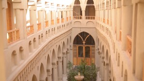 A courtyard with arches, a central fountain, and a wooden door. - Embrace Hotel (Luxor)