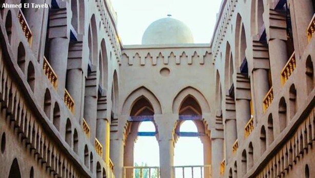 A courtyard with a central fountain, arches, and a dome in the background. - Embrace Hotel (Luxor)